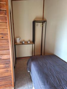 a bedroom with a bed and a table in a room at Hosteria Lago Sur in El Calafate