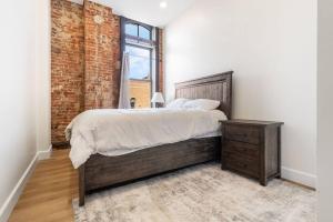 a bedroom with a large bed and a brick wall at Clay St Suite in Millersburg