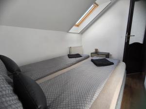 two beds in a bedroom with a skylight at Morrison Rezidence in Miercurea-Ciuc