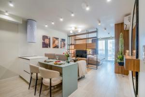 a kitchen and living room with a table and chairs at MyFlat Wave Luxury 44 Suite in Siófok