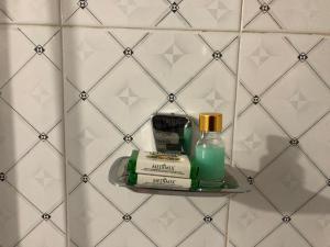 a shelf with toiletries on a tiled wall at Nature Inn Cottages in Gokarna
