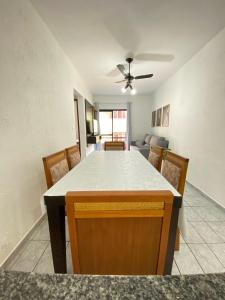 a kitchen and dining room with a table and chairs at Pé na Areia Canto do Forte III in Praia Grande