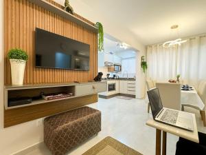 un salon avec une télévision et un ordinateur portable sur une table dans l'établissement Res. Villa de Collina - Centro de Floripa - CEN002, à Florianópolis