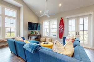 a living room with a blue couch and a table at Happiness Radiater at Palmilla Beach in Port Aransas
