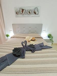 Una cama con sombrero y ropa. en Eccellente appartamento in posizione strategica, en Arona