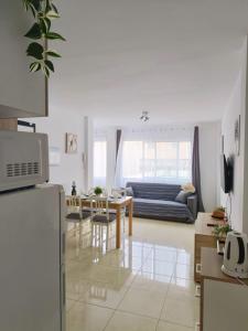 Una cocina y una sala de estar con una mesa y un sofá. en Eccellente appartamento in posizione strategica, en Arona