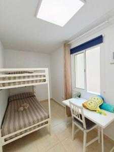 1 dormitorio con literas, mesa y escritorio en Eccellente appartamento in posizione strategica, en Arona