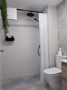 a bathroom with a white shower curtain and a toilet at Paseo Marítimo Aguadulce in Aguadulce