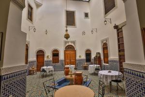 a room with tables and chairs in a building at Riad Nashira in Fez