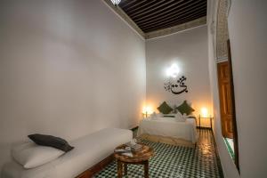 a living room with a couch and a bed at Riad Nashira in Fès