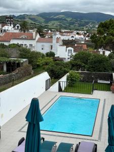 a swimming pool on a patio with chaise lounge chairs at Casa da Lara in Lagoa