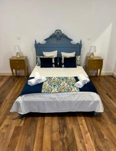 a bedroom with a blue bed with two night stands at Casa da Lara in Lagoa +36 photos
