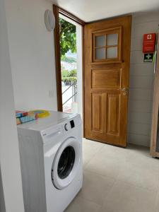 a washing machine in a room with a door at Casa da Lara in Lagoa