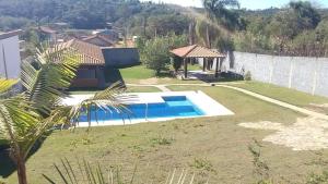a house with a swimming pool in a yard at Chácara com piscina e amplo espaço gourmet à sete min da famosa estrada do roteiro do vinho in Ibiúna
