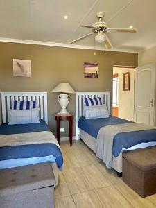 a bedroom with two beds and a ceiling fan at Country Lane Farm lodge in Cradock