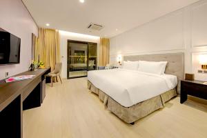 a hotel room with a large bed and a television at Golden Apartment in Da Nang Bay in Danang +29 photos