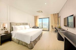 a hotel room with a large bed and a desk at Golden Apartment in Da Nang Bay in Danang