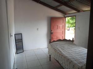 a bedroom with a bed and a red door at Guadalupe Herrera in Tola