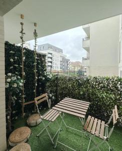 a patio with a bench and a table and chairs at Spacieux appart terrasse métro hôpital 4pers wifi in Villejuif