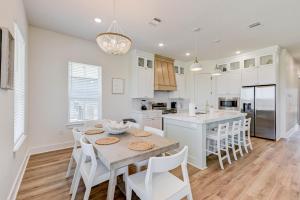 a white kitchen with a table and white chairs at Salt & Stone Villas in Galveston