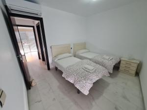 two beds in a room with a window at REf 107 DUPLEX DUNA PLAYA ZAHARA in Zahara de los Atunes