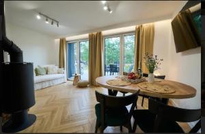 a living room with a table and chairs and a couch at Domek wśród sosen in Borsk