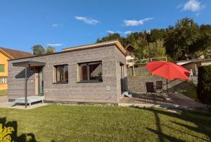 a small house with a red umbrella in the yard at TinyHouse - (D)ein Ferienhaus in Schellenberg +14 photos