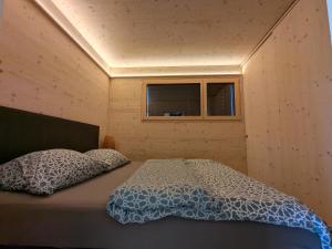 a bed in a small room with a window at TinyHouse - (D)ein Ferienhaus in Schellenberg