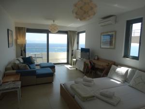 a living room with a couch and a living room with the ocean at Endless Blue - Rafina Seaview Apartment in Rafina