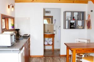 - une cuisine avec des murs blancs et une table en bois dans l'établissement Madre e Hija (refugio de montaña), à El Chalten