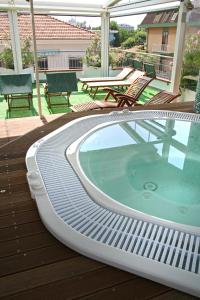 a hot tub on a deck with chairs and a table at Hotel Cadiz in Rimini