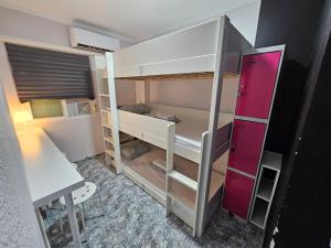 a small room with a bunk bed and a desk at Habitación Familiar in Madrid