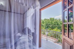 a room with a window with a bed and a balcony at Villa Wedamulla in Unawatuna