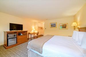 a hotel room with a bed and a flat screen tv at Town & Country Inn & Resort in Gorham