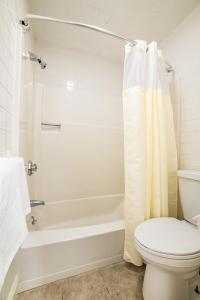 a bathroom with a white tub and a toilet at Town & Country Inn & Resort in Gorham