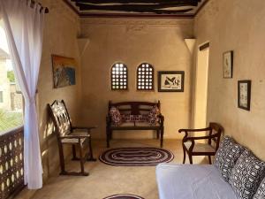a living room with a couch and two chairs at Umma House in Lamu