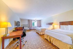 a hotel room with two beds and a desk at Town & Country Inn & Resort in Gorham