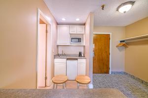 a small kitchen with two stools and a counter at Town & Country Inn & Resort in Gorham