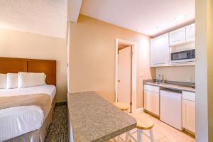 a small hotel room with a bed and a kitchen at Town & Country Inn & Resort in Gorham