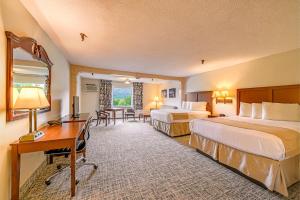 a hotel room with two beds and a desk at Town & Country Inn & Resort in Gorham