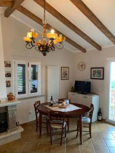 a dining room with a table and a chandelier at Villetta panoramica Le Ginestrelle in Pescopagano