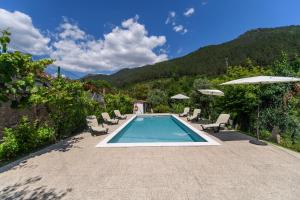 a swimming pool with chairs and umbrellas on a patio at Afonso's House Gerês I in Braga
