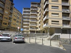 two cars parked in a parking lot in front of a building at Lugo Apartamento nuevo en centro de la ciudad in Lugo