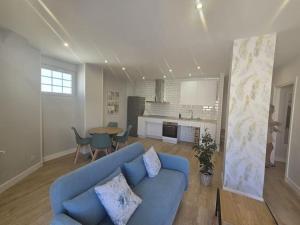 a living room with a blue couch and a kitchen at Lugo Apartamento nuevo en centro de la ciudad in Lugo