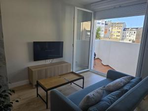 a living room with a couch and a flat screen tv at Lugo Apartamento nuevo en centro de la ciudad in Lugo