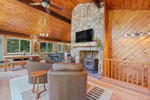 a living room with a stone fireplace and a tv at Belleau Lake Escape in Wakefield