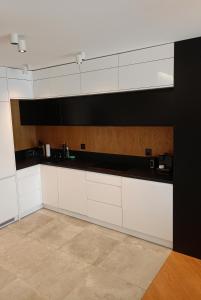 une cuisine avec des armoires blanches et des comptoirs noirs dans l'établissement Apartament Glamour z wyjątkowym widokiem i klimatyzacją, à Ustroń