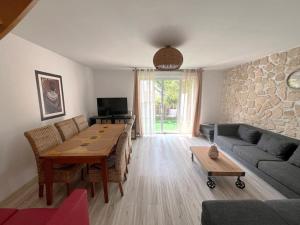 ein Wohnzimmer mit einem Tisch und einer Steinmauer in der Unterkunft Maison cosy à Vaires sur Marne in Vaires-sur-Marne
