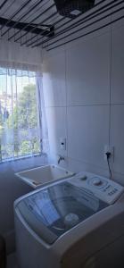 a bathroom with a tub and a sink and a window at Apartamento Confortável Inteligente in Poços de Caldas +22 photos