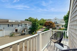 a balcony with two chairs and a house at Oyster Beach Bungalow in Chatham